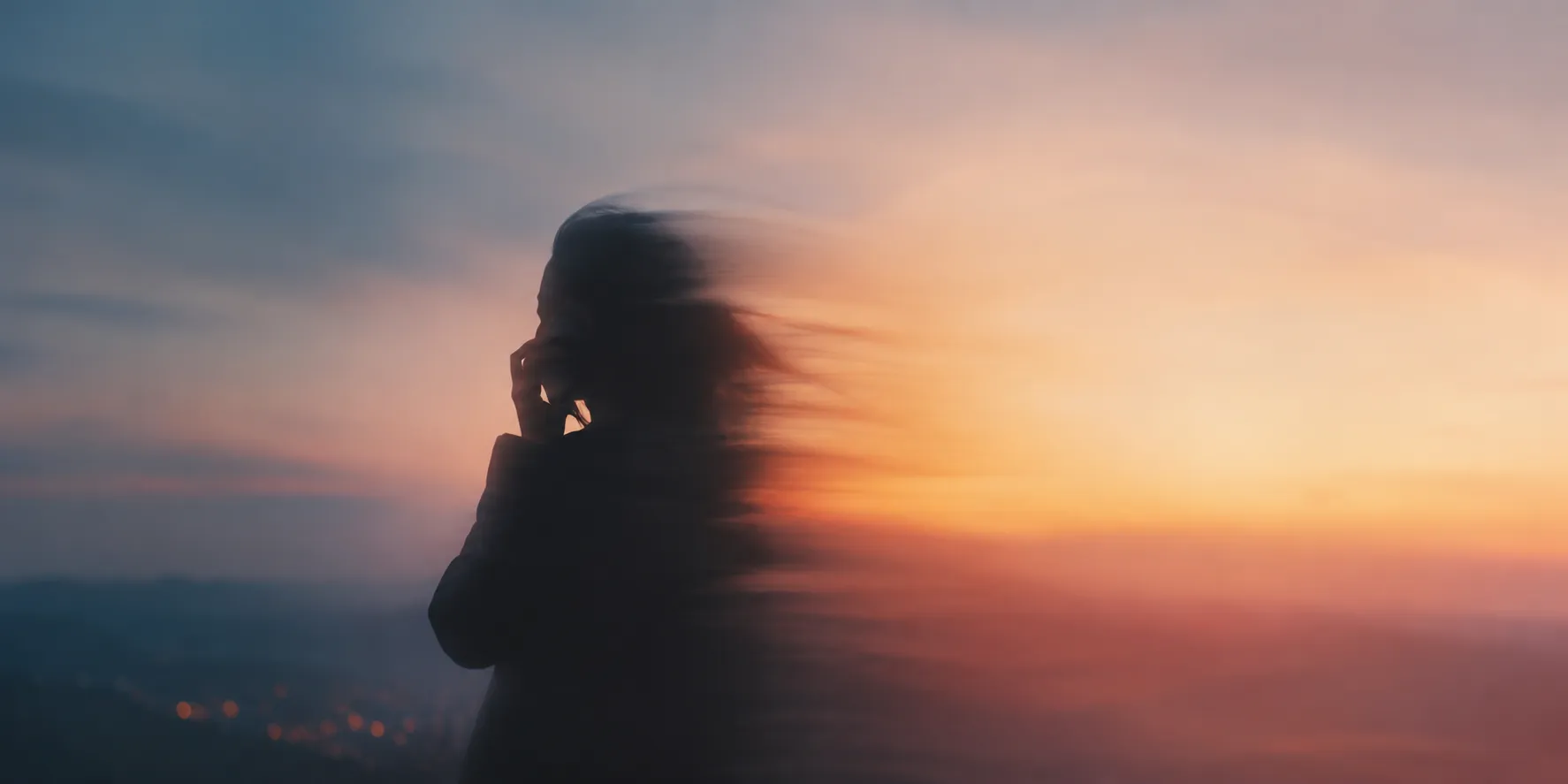 Silueta de una persona hablando por teléfono al atardecer